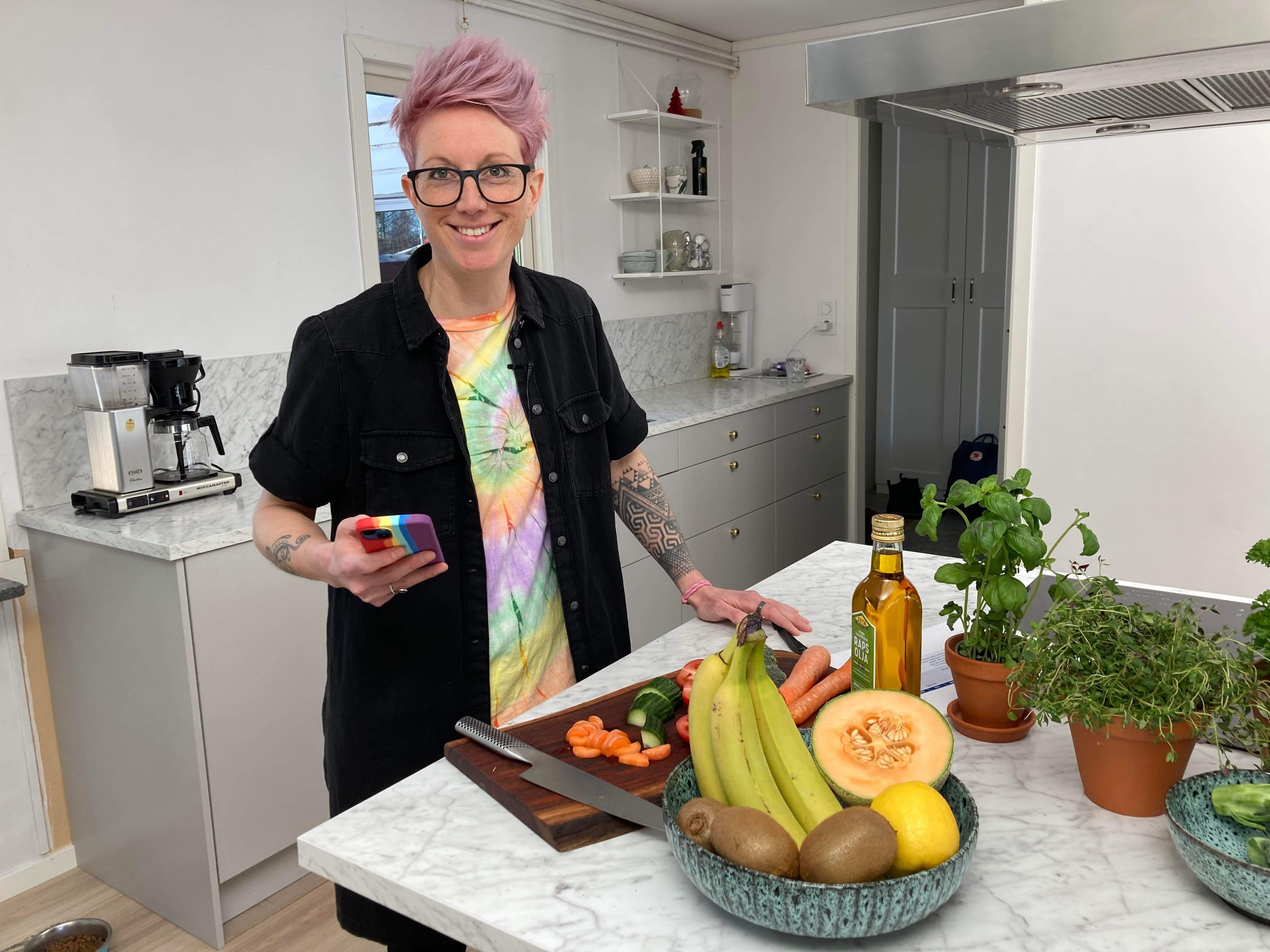 kvinna i ett kök med frukt, grönsaker och kryddor
