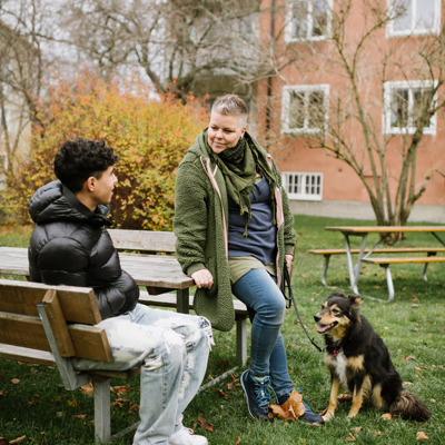 en kvinna talar med en ung kille utomhus