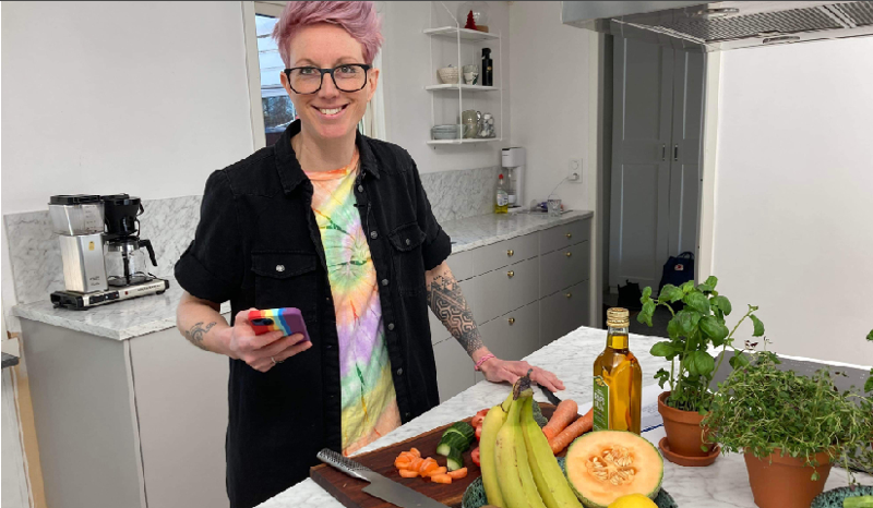 Malin Sand står i ett kök med mycket grönsaker