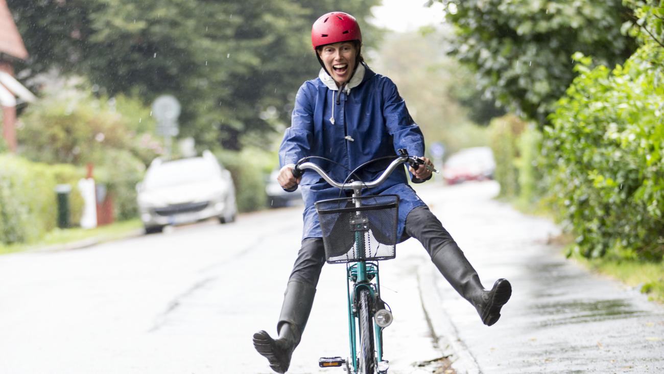 En glad kvinna sitter på en cykel.