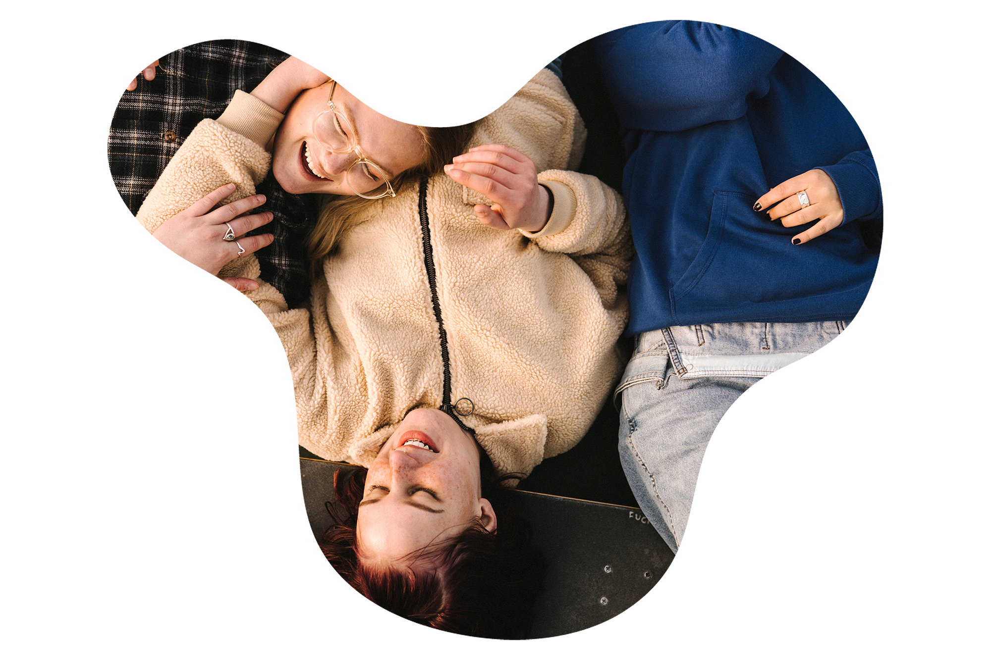 En grupp glada ungdomar ligger p&aring; golvet