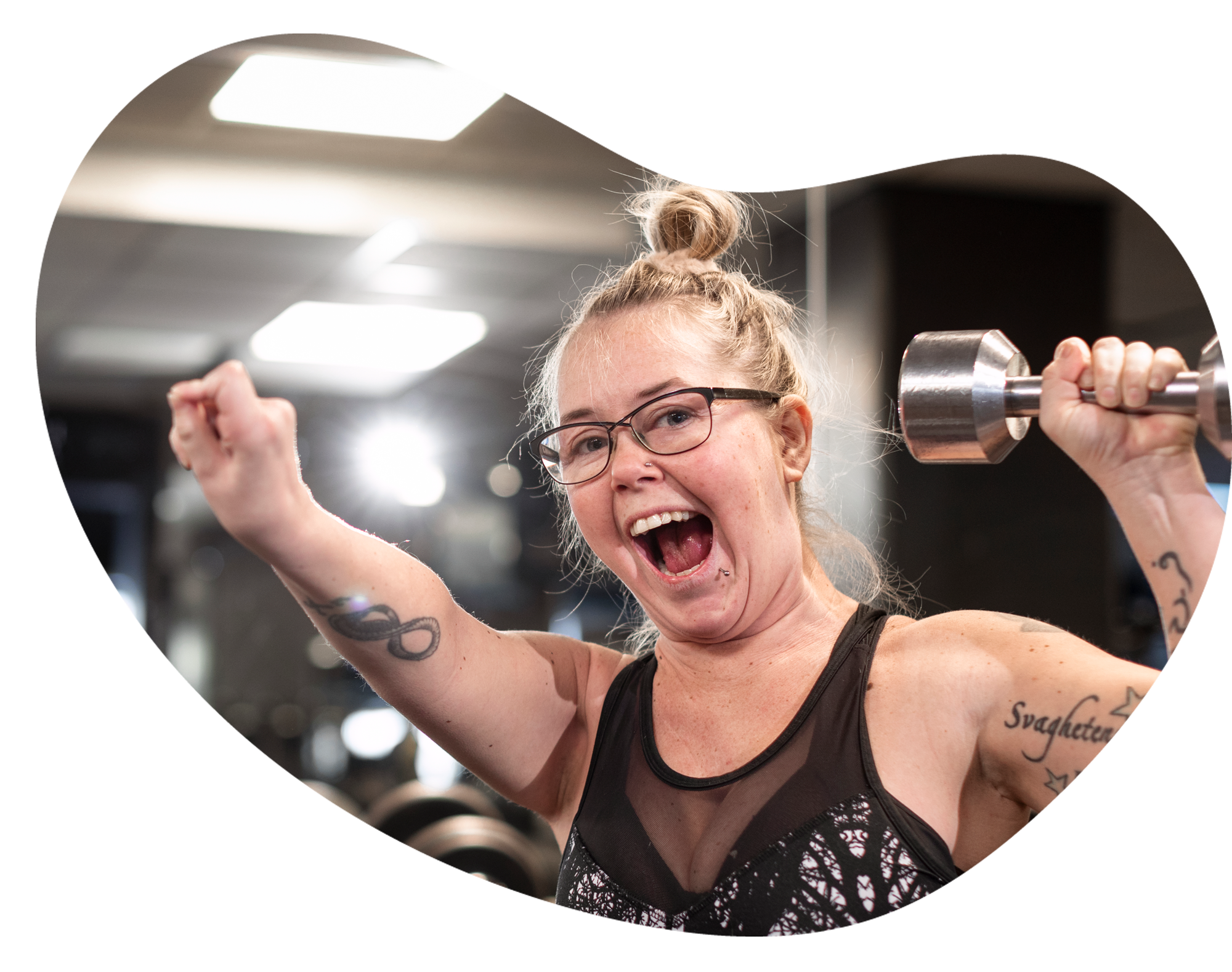 En glad kvinna tr&auml;nar med hantlar