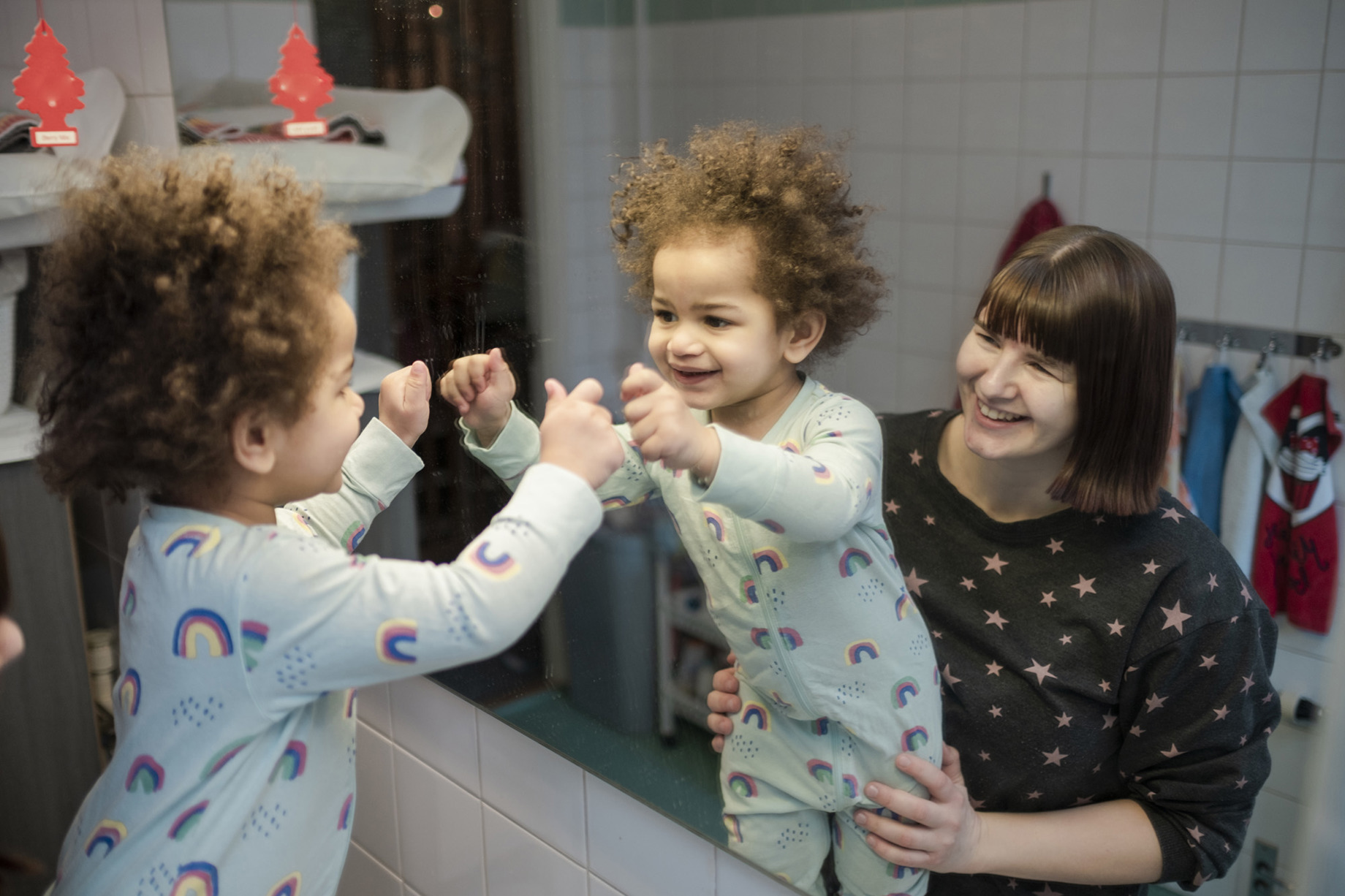 ett litet barn framför spegeln tillsammans med kvinna