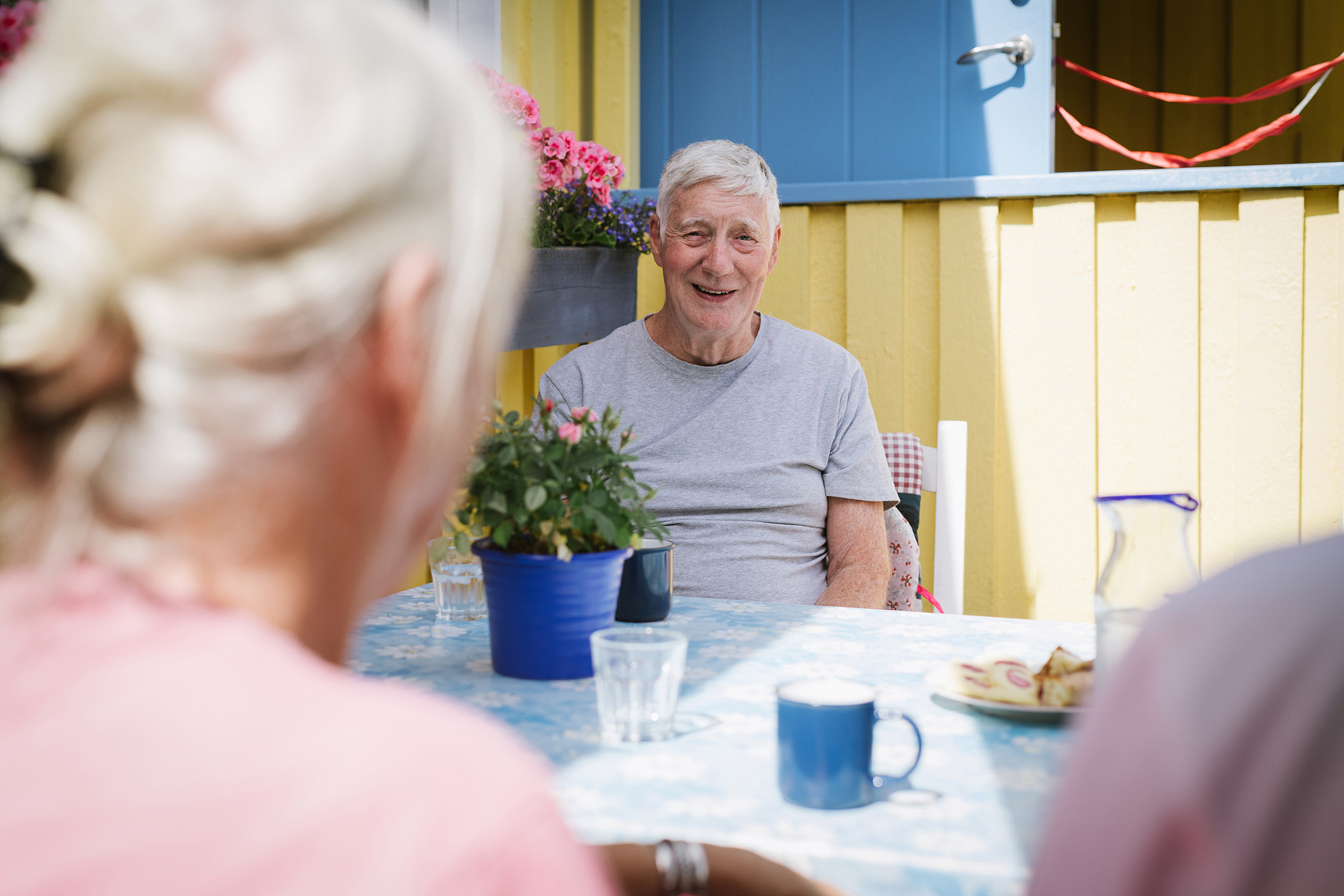 en äldre man och kvinna sitter vid fikabordet utomhus