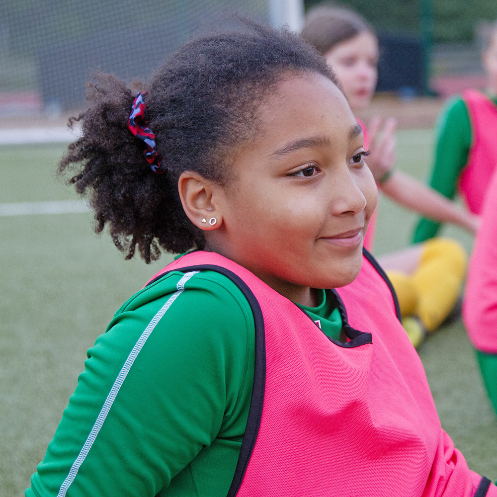 Tjej som sitter, hon har tr&auml;ningskl&auml;der p&aring; sig