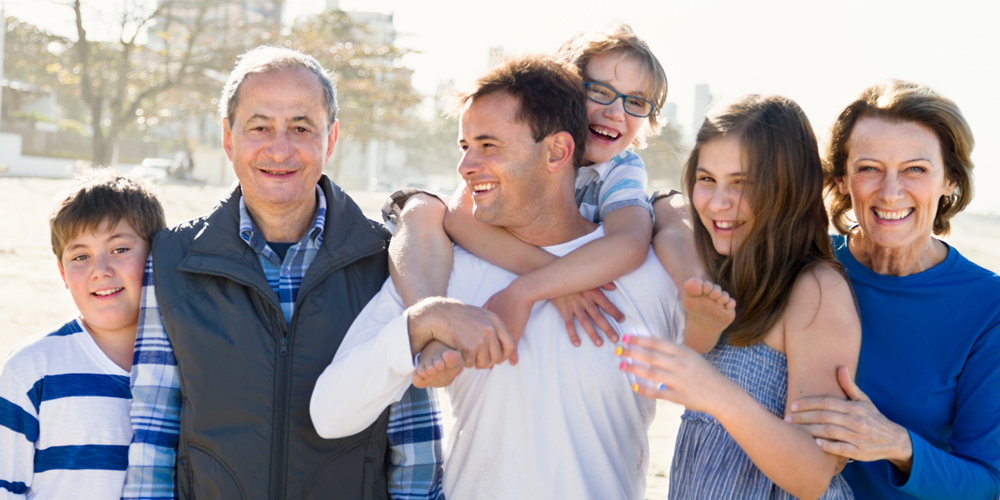 En grupp av människor i olika åldrar står tillsammans och tittar in i kameran.